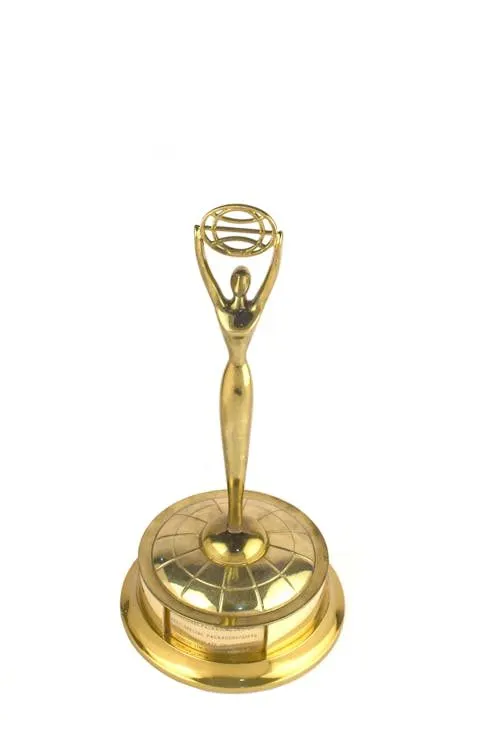 Gold trophy on display at a prestigious award ceremony representing excellence in millinery design