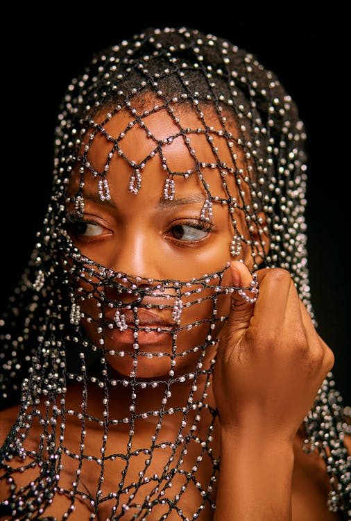 Intriguing portrait of a woman adorned with a shimmering beaded veil and ornate headpiece
