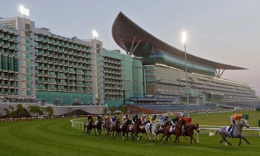 Dubai World Cup horses racing on the turf track at Meydan Racecourse with spectacular grandstand architecture