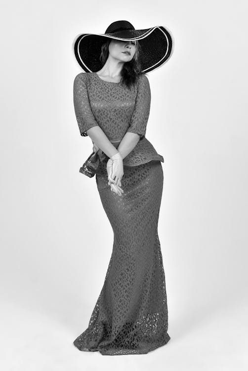 Elegant woman in a monochrome outfit and structured hat capturing the understated elegance of Oaks Day