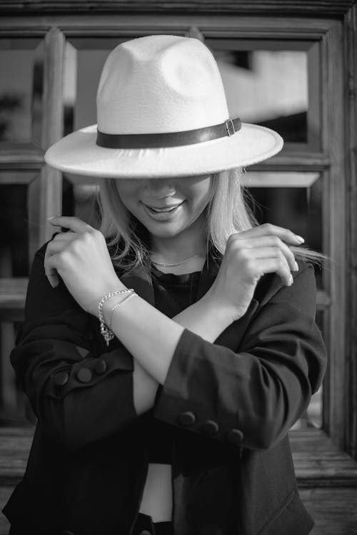 Elegant woman in a fedora hat with a stylish pose demonstrating proper hat wearing at events