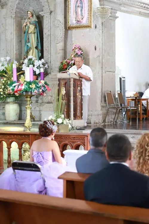 Formal wedding ceremony inside a beautifully decorated church with elegantly dressed guests