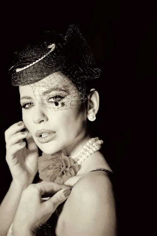 Close-up portrait of a woman in an ornate fascinator headpiece showcasing formal racing millinery detail