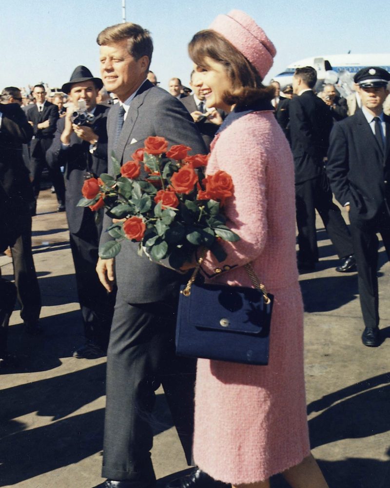 Jackie Kennedy wearing her iconic pink pillbox hat and matching Chanel suit, one of the most recognisable hats in political history