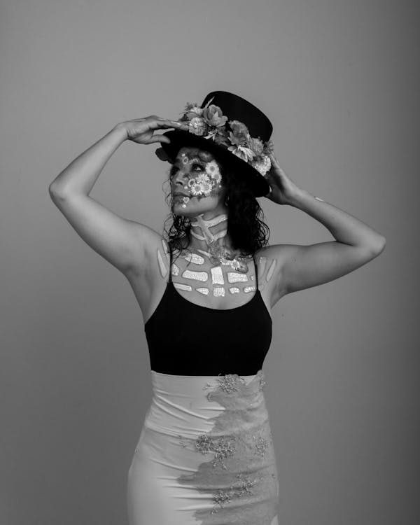 Artistic woman wearing a sculptural floral hat showcasing the modern trend of wearable art in avant-garde millinery