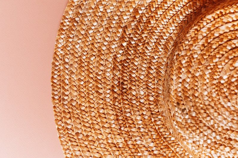 Close-up of a natural woven straw hat highlighting the 2026 trend toward organic and sustainable millinery materials