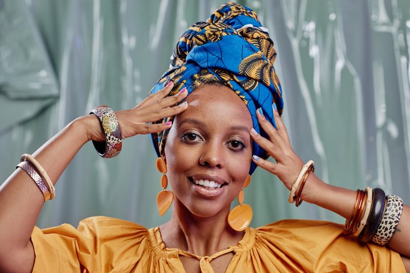 Stylish woman wearing an oversized turban-style headwrap reflecting the trending move toward bold wrapped headpieces