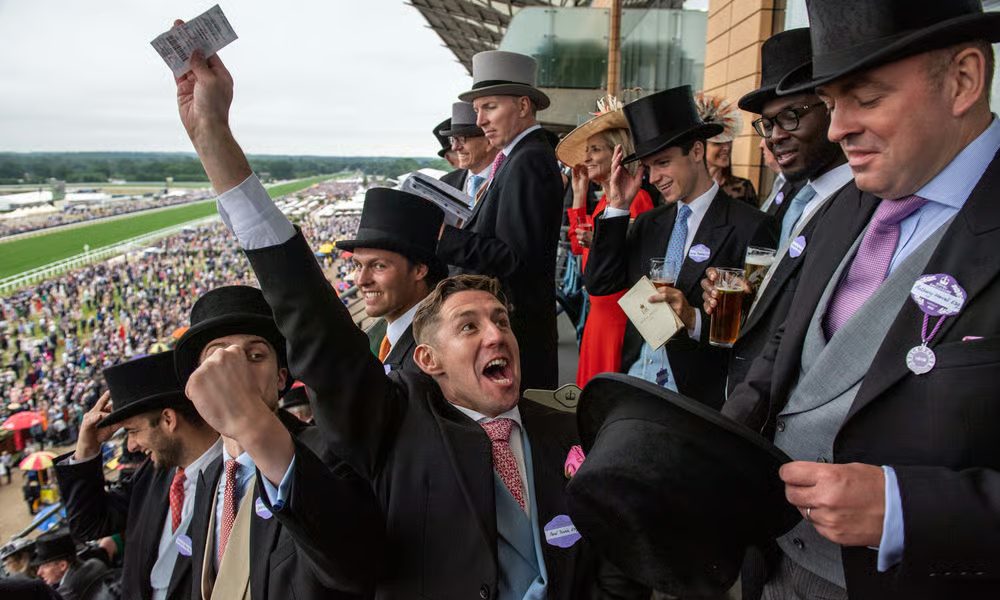 Royal Ascot racegoers celebrating in morning dress and top hats at the grandstand with betting tickets