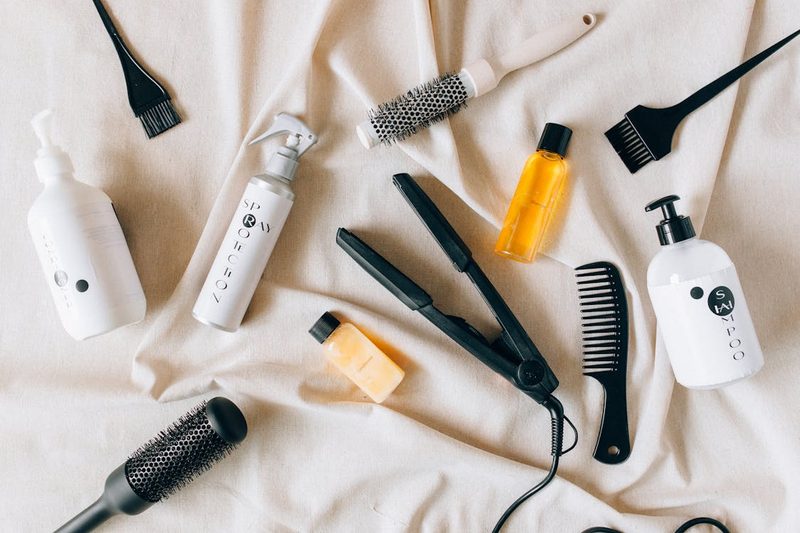 Flat lay of hair styling products and accessories including pins and clips used for securing headband fascinators