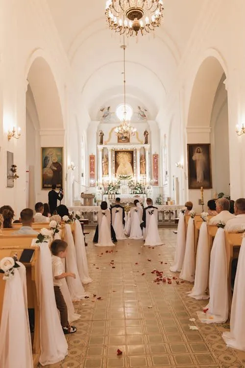Wedding ceremony guests seated inside an elegant church dressed in formal attire