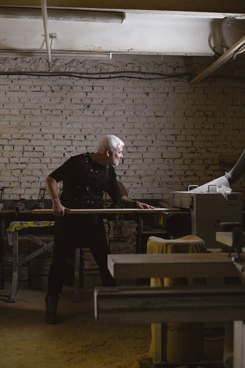 Professional artisan shaping a wooden form with a planing machine in a traditional craft workshop
