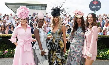 Ladies day racing fashion winners wearing dramatic pink floral hats and elegant outfits at the races