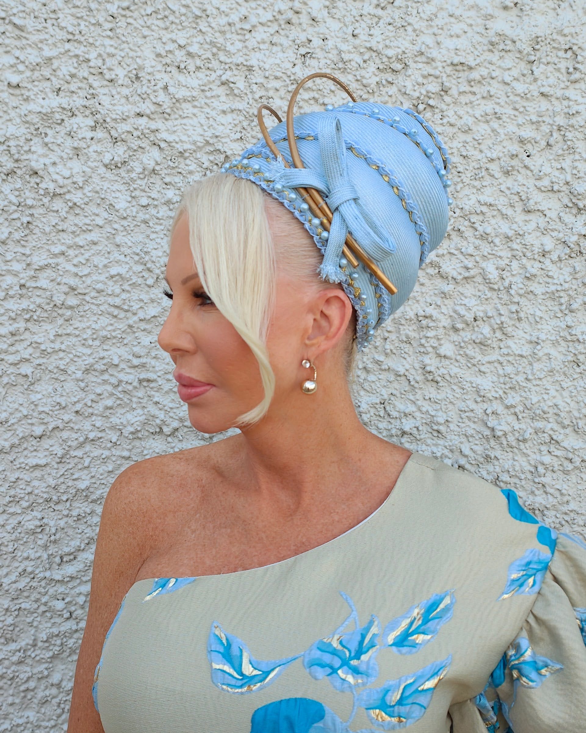 Side profile of handcrafted blue straw turban by Kathryn Lee Millinery with braided detail and gold quills