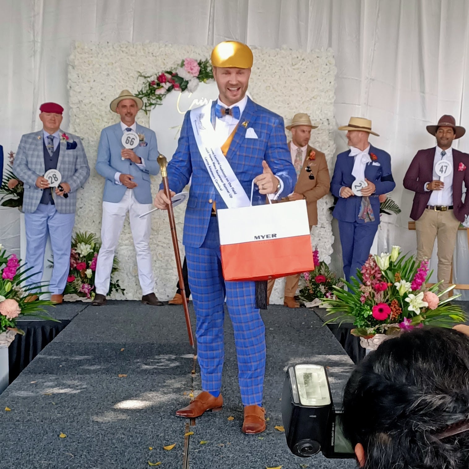 Fashions on the field winner in gold beret by Kathryn Lee Millinery collecting Myer prize at spring racing carnival