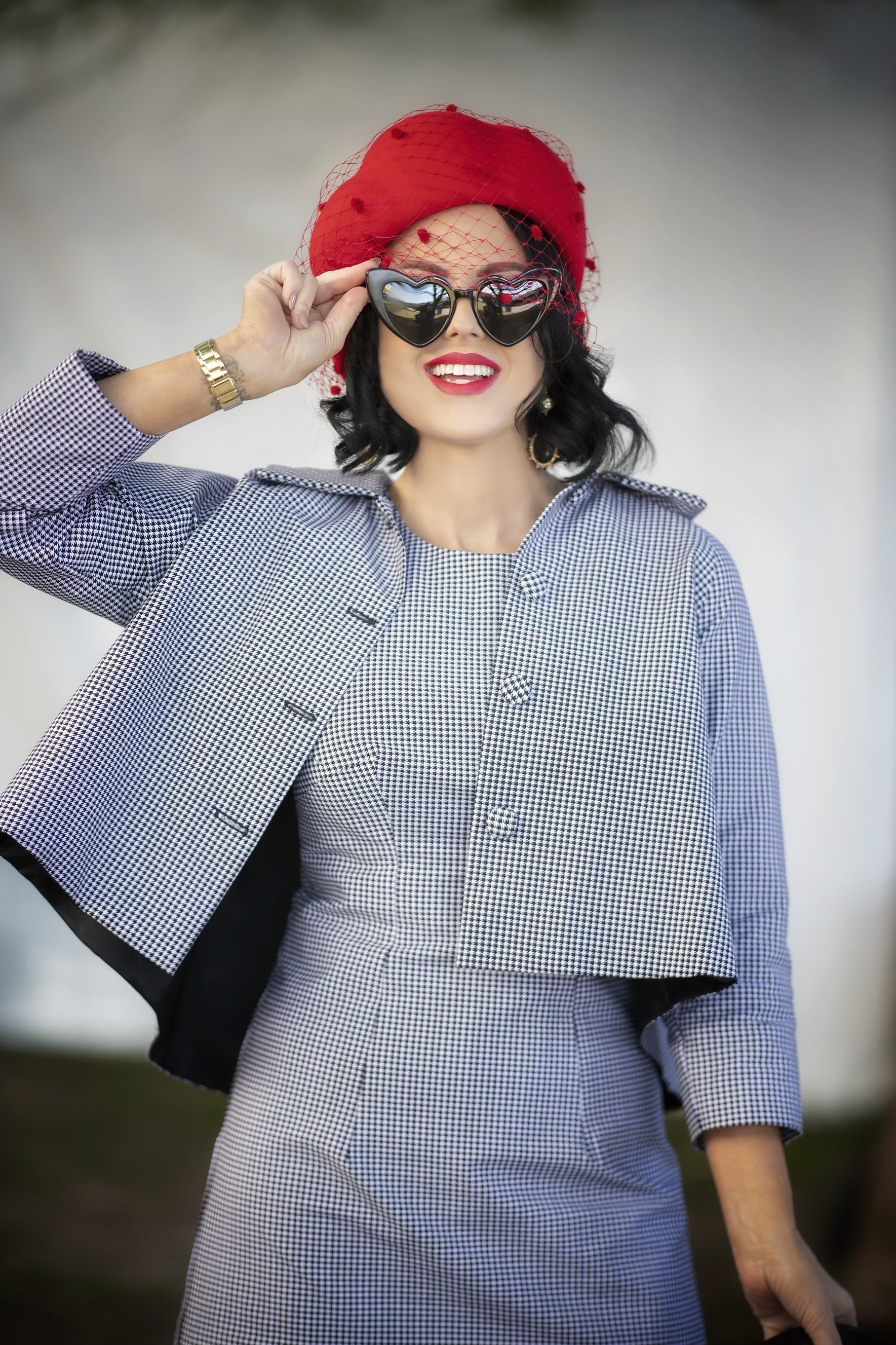 Vintage-inspired red beret with veiling by Kathryn Lee Millinery styled with retro checkered outfit for race day