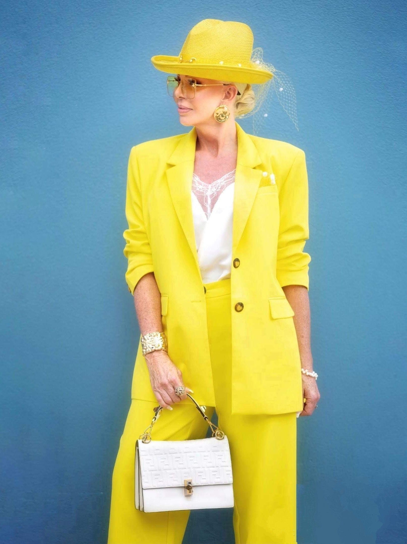 Client wearing yellow straw fedora hat by Kathryn Lee Millinery with matching yellow suit - bold race day fashion